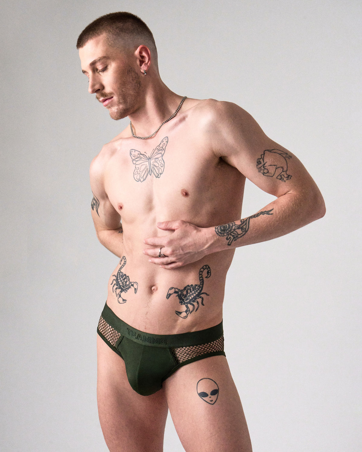 Edge Net Brief in Forest, front view on model showing the men's sheer net side panels and pouch
