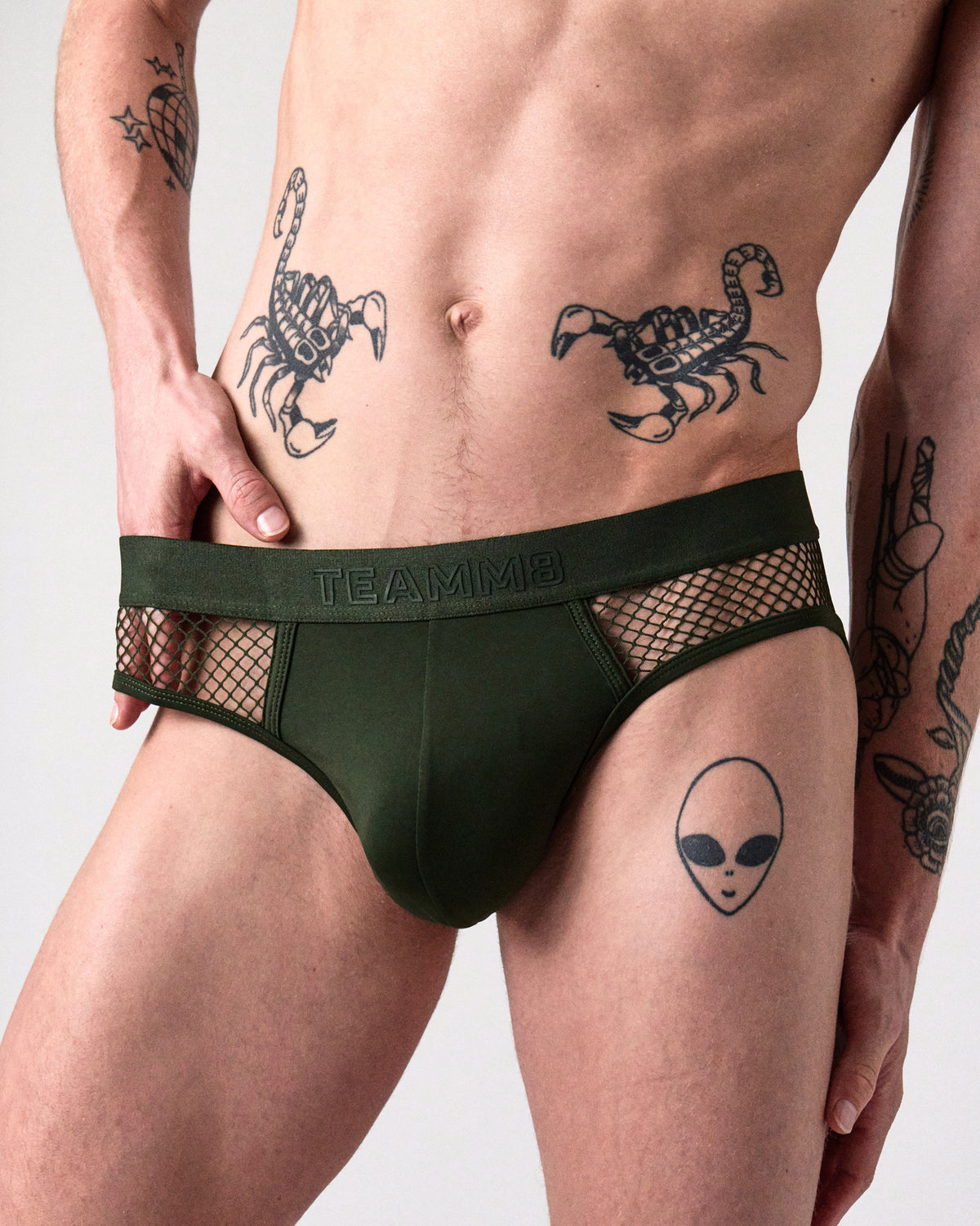 Edge Net Brief in Forest, front close-up of the pouch, TEAMM8 waistband and net side panels