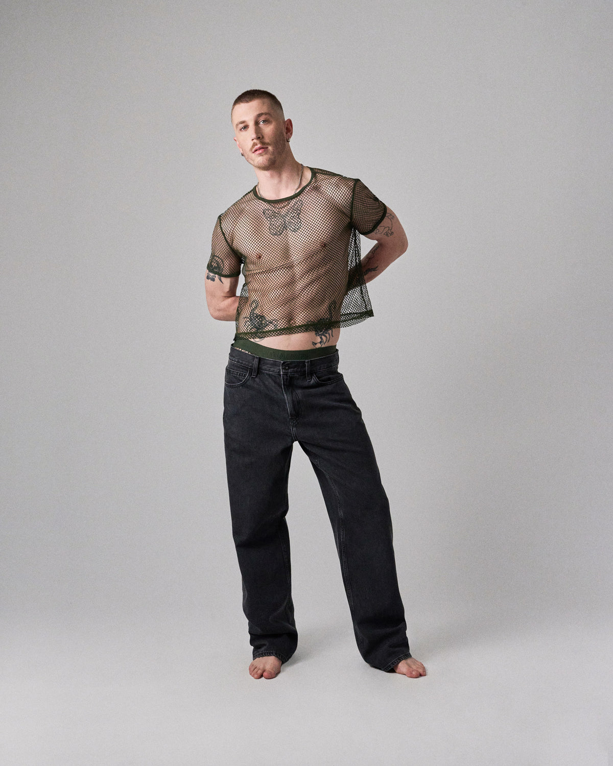 Edge Net Cropped Tee in Forest, men's sheer net crop top, full-length front view with jeans