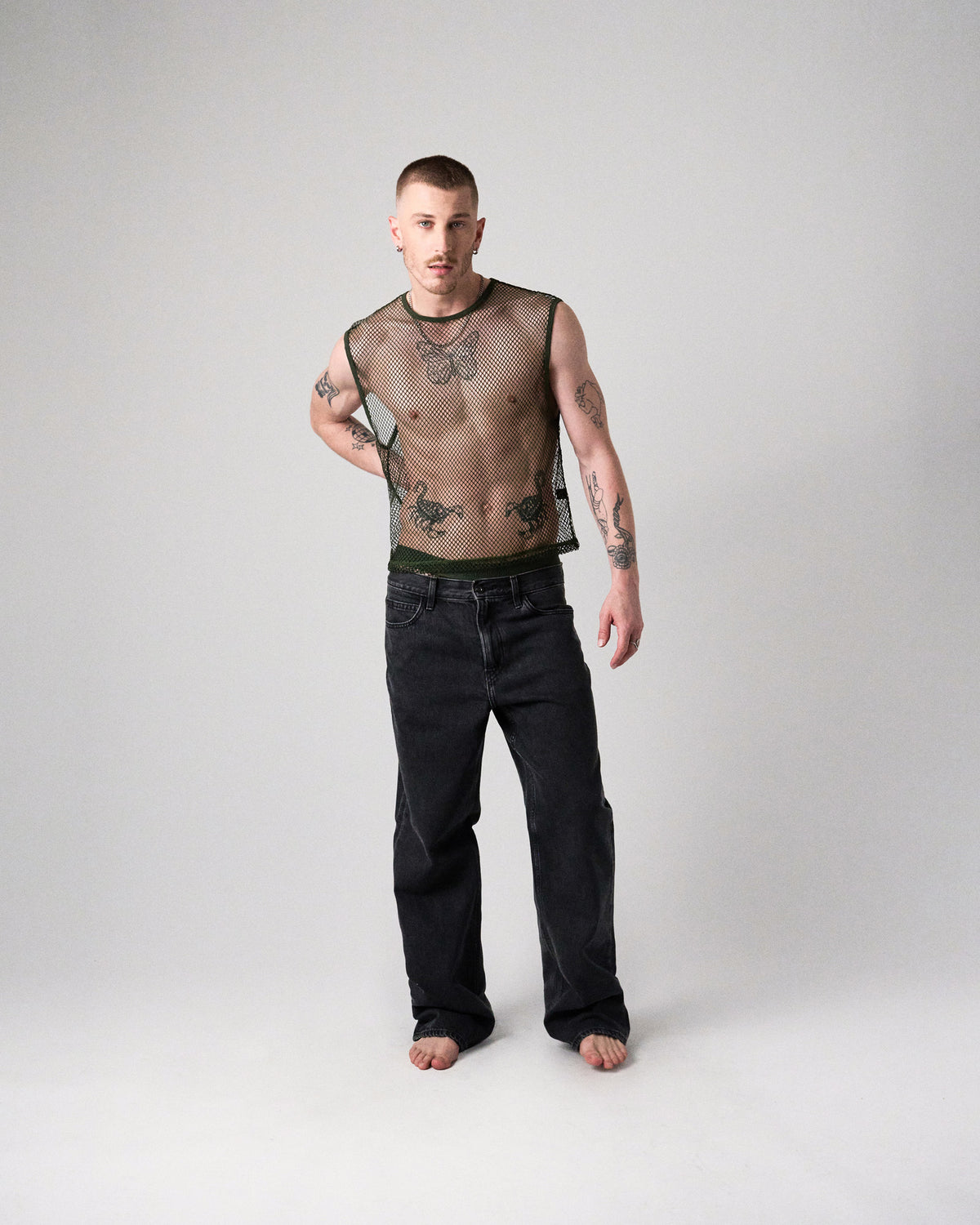 Edge Net Muscle Tank in Forest, men's sheer net sleeveless top, full-length front view with jeans