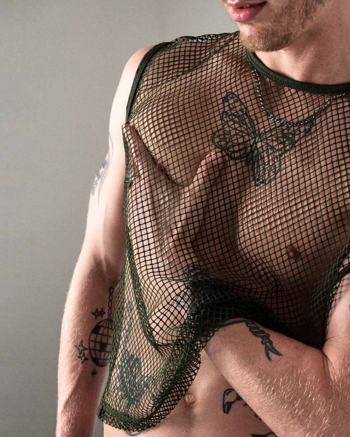 Edge Net Muscle Tank in Forest, close-up of the net fabric and piped armhole at the chest