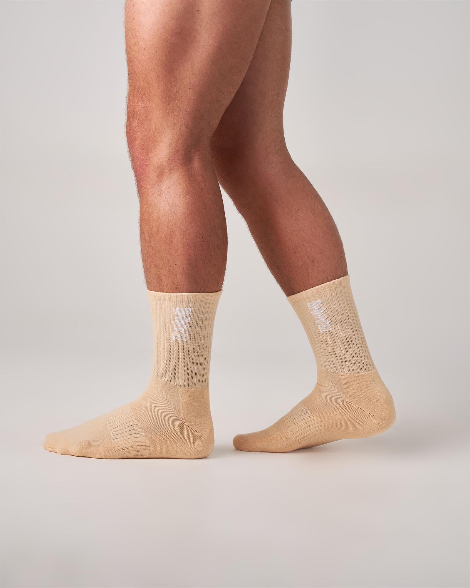 Beige socks worn by a person on a light gray background